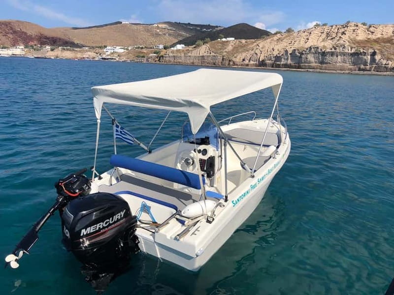 Santorini: License-Free Boat Rental with Ice, Water, & Fruit - Taking the helm near Santorini’s volcanic caldera